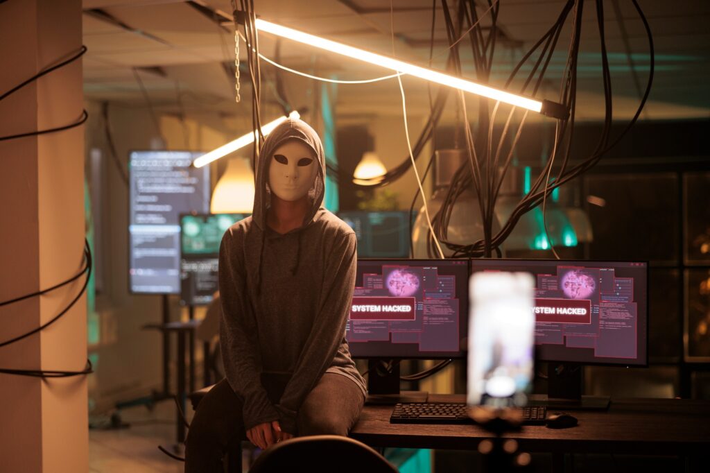 Anonymous hacker attacking database server portrait, cybercrime